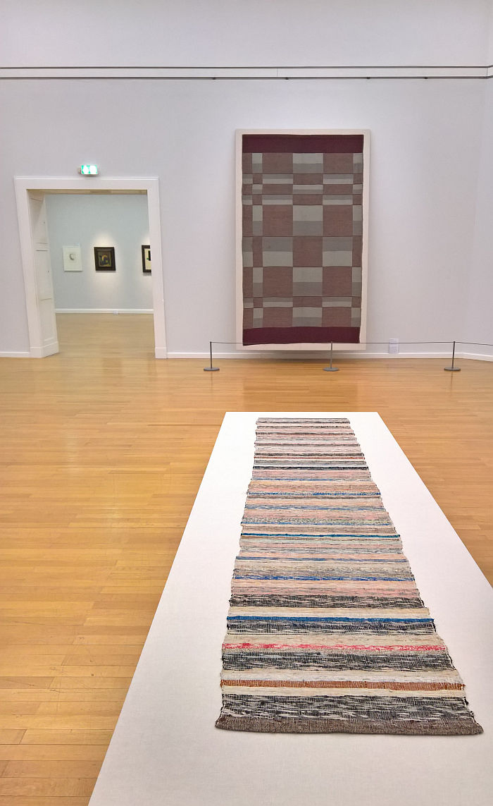 Rag rug by Helene Schmidt-Nonné (foreground) and a wall hanging from Burg Giebichenstein Halle (rear), as seen at Bauhaus. Textiles and Graphics, Kunstsammlungen Chemnitz