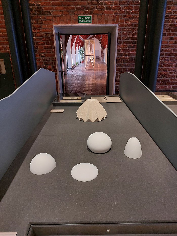 Examples of circular rotational forms (front) and model of a prefabricated centrally folded form building (rear) by Witold Lipiński, as seen at Shape of Dreams. The Architecture of Witold Lipiński, Muzeum Architektury, Wrocław