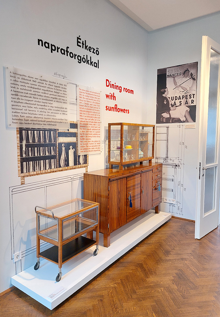 1930s furniture by Kaesz Gyula and a photo of Lukáts Kató in front of a poster by her for the 1935 Budapest Vásár, as seen in Kaesz Homes 1925-1960. The homes of designer couple Kaesz Gyula and Lukáts Kató, Walter Rózsi Villa, Budapest