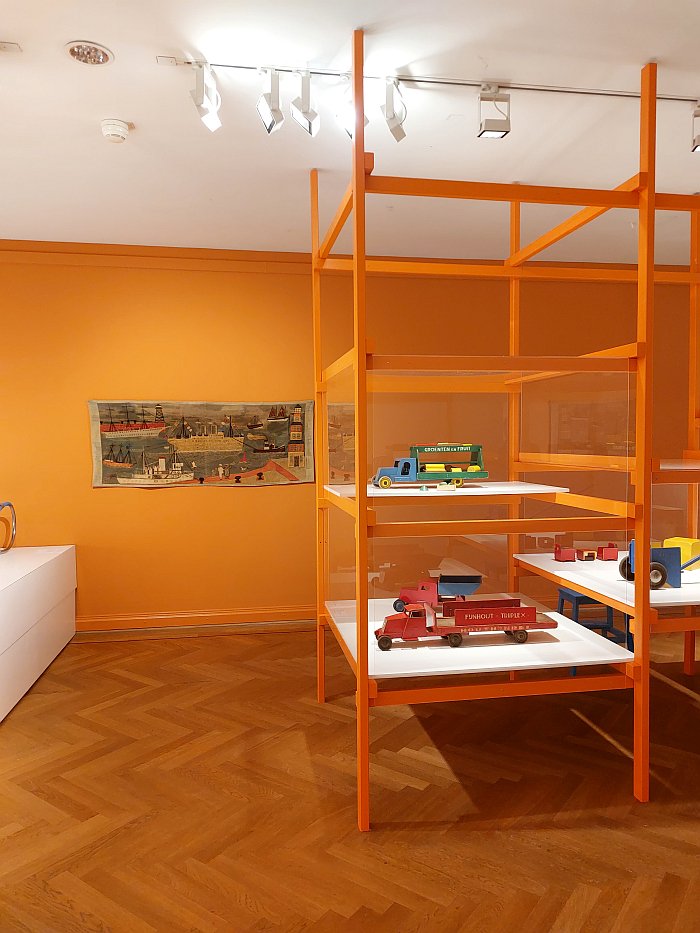 A tapestry by Elisabeth Kadow and toy trucks by Ko Verzuu, as seen at Design for Children, Bröhan Museum, Berlin