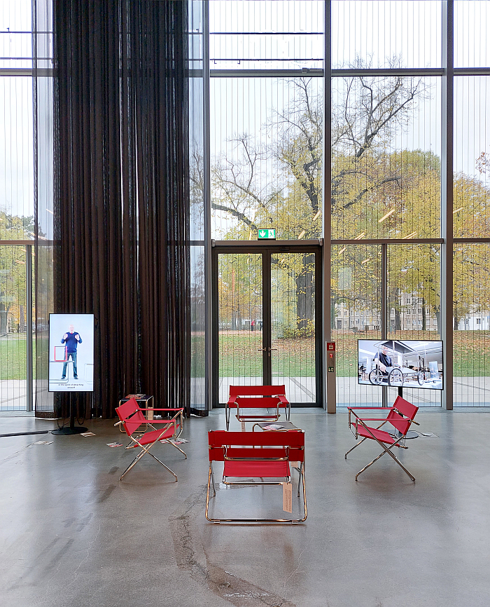 A collection of D4s by Marcel Breuer through Tecta in the Bauhaus Museum Dessau watching Tecta co-founder Axel Bruchhäuser explain the (hi)story of steel tube furniture (l) and a video of Tecta at work (r), as seen in context of Mehr als echt (More than real) by Jun Yang, Stiftung Bauhaus Dessau